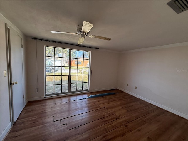 spare room with ceiling fan, wood finished floors, visible vents, and baseboards