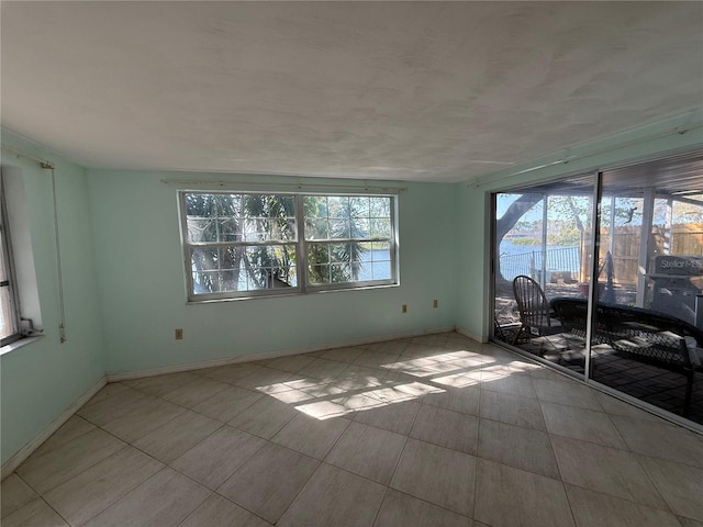 empty room with plenty of natural light and baseboards