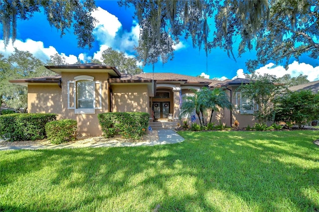 mediterranean / spanish-style home featuring a front yard and stucco siding