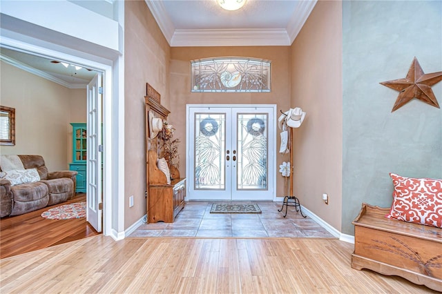 entrance foyer featuring french doors, crown molding, baseboards, and wood finished floors