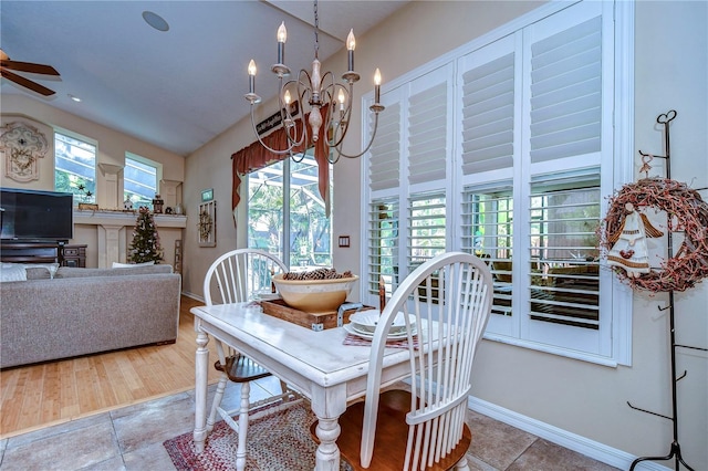 dining room with ceiling fan with notable chandelier and baseboards