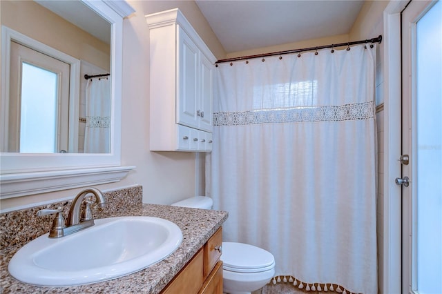 bathroom featuring toilet, curtained shower, and vanity