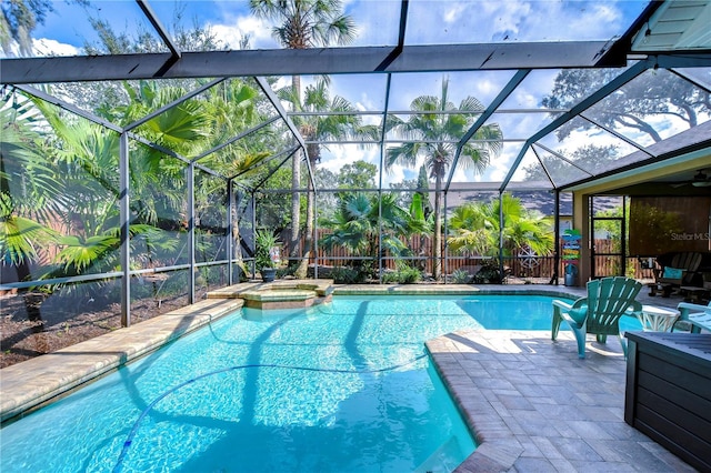 view of swimming pool with glass enclosure, a patio area, and fence