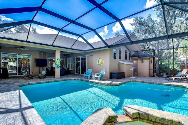 view of pool with a lanai, a pool with connected hot tub, a ceiling fan, and a patio