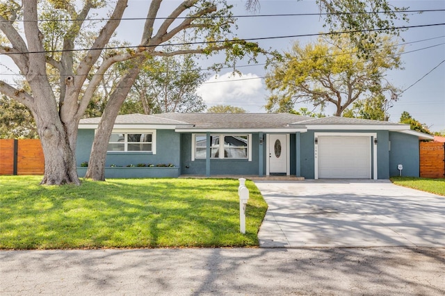 single story home with a front lawn, fence, concrete driveway, stucco siding, and an attached garage