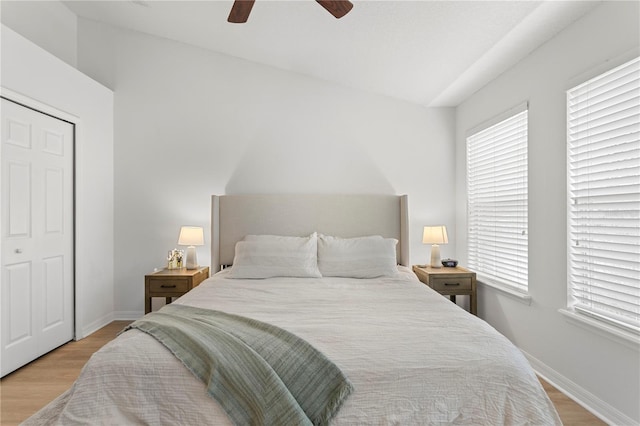 bedroom featuring light wood-style floors, lofted ceiling, ceiling fan, and baseboards