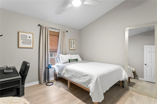 bedroom with vaulted ceiling, light wood-type flooring, a ceiling fan, and baseboards