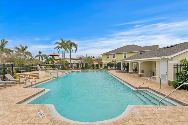 community pool with a patio and fence