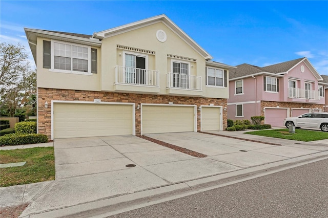 view of property with a garage, concrete driveway, and stucco siding