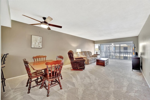 dining room with baseboards, carpet flooring, a textured ceiling, and a ceiling fan