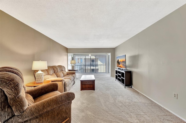 living area featuring baseboards, light carpet, and a textured ceiling