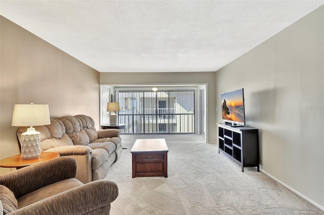 living area with a textured ceiling, baseboards, and carpet floors