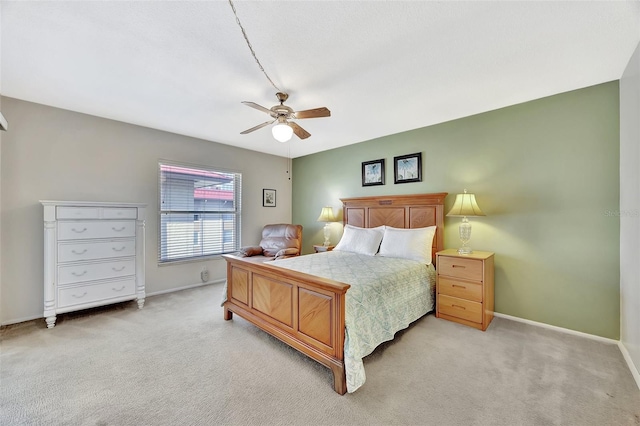 bedroom with light carpet, a ceiling fan, and baseboards