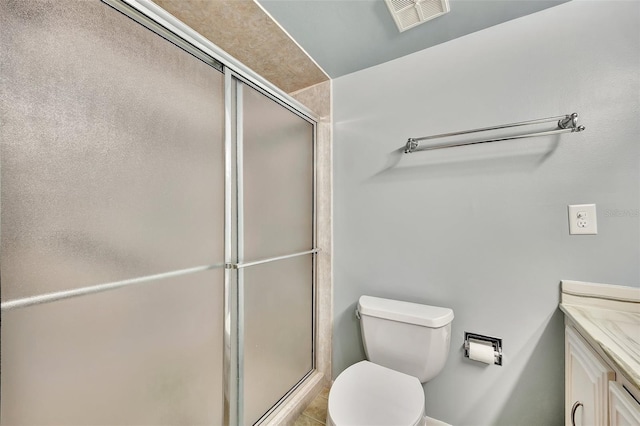 bathroom featuring visible vents, vanity, toilet, and a shower stall