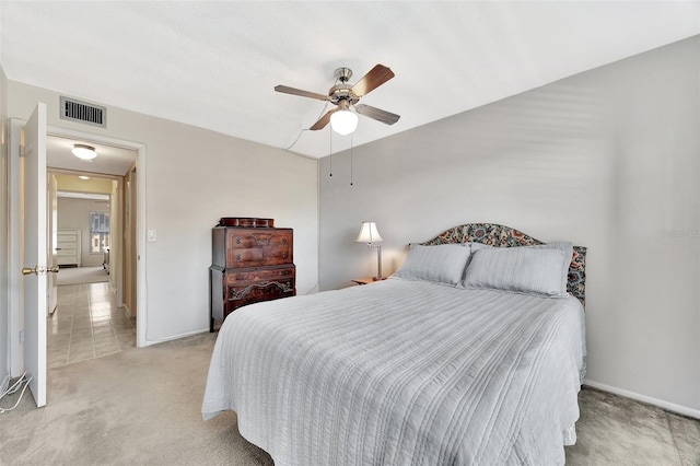 bedroom featuring ceiling fan, baseboards, visible vents, and light carpet