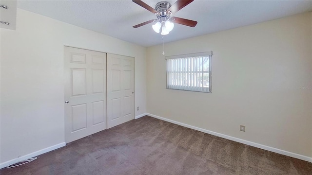 unfurnished bedroom with ceiling fan, a closet, baseboards, and carpet flooring