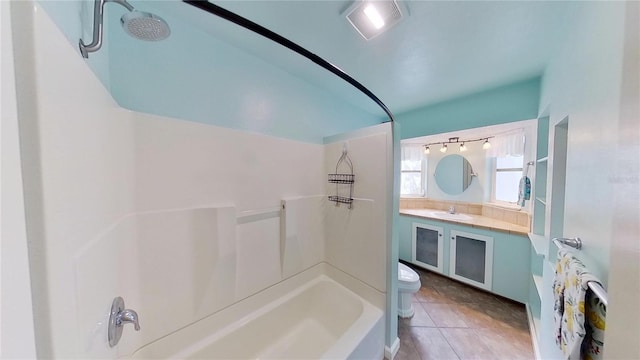 full bathroom featuring toilet, tile patterned flooring, vanity, and bathing tub / shower combination