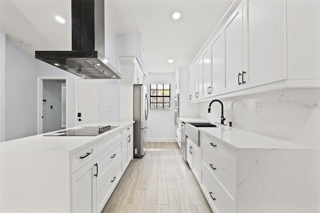 kitchen featuring a sink, freestanding refrigerator, light wood finished floors, black electric cooktop, and extractor fan