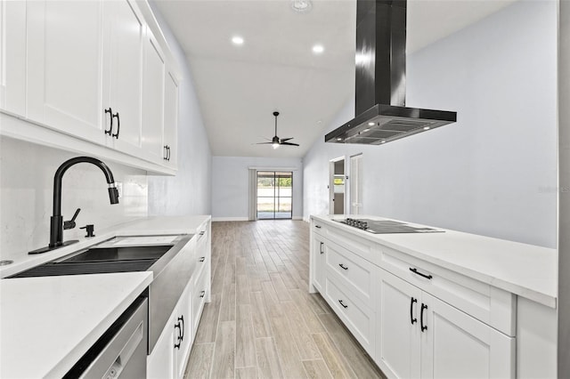 kitchen featuring a sink, ventilation hood, light wood finished floors, black electric cooktop, and light countertops