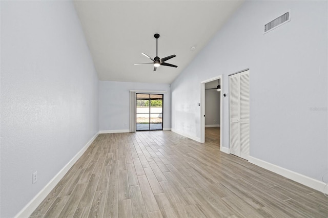 empty room with visible vents, baseboards, light wood-style floors, high vaulted ceiling, and a ceiling fan