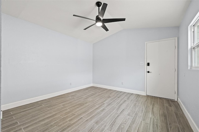 spare room with ceiling fan, baseboards, wood finished floors, and vaulted ceiling