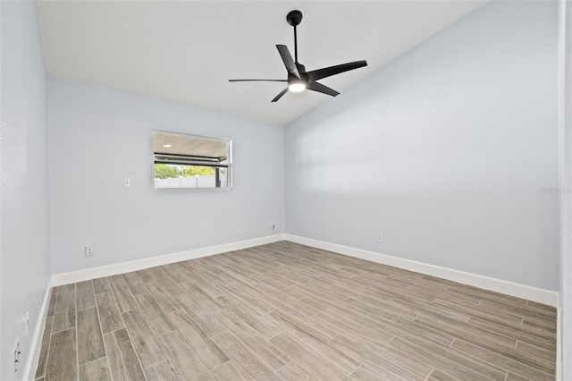 spare room with a ceiling fan, vaulted ceiling, baseboards, and light wood-type flooring