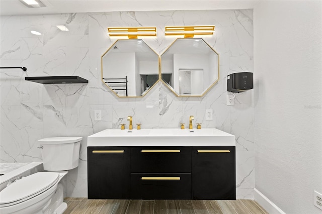 full bath with visible vents, toilet, a sink, double vanity, and wood tiled floor