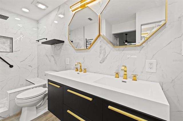 bathroom with double vanity, toilet, a marble finish shower, and a sink