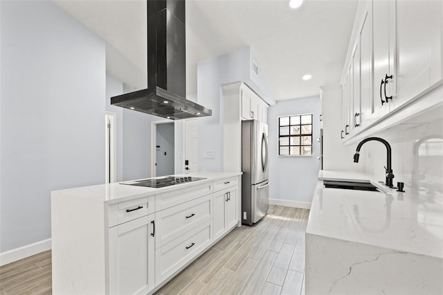 kitchen featuring a sink, exhaust hood, wood tiled floor, and freestanding refrigerator