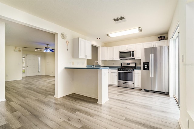 kitchen featuring light wood finished floors, white cabinetry, visible vents, and stainless steel appliances