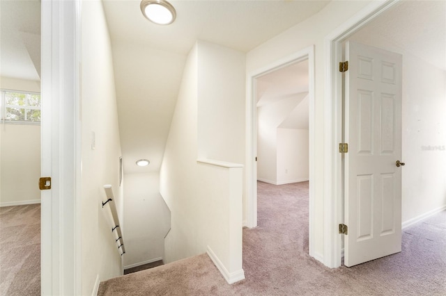 interior space with baseboards, carpet flooring, and an upstairs landing