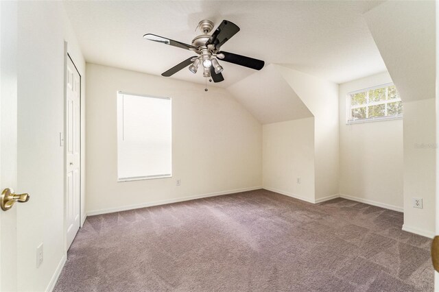 bonus room with vaulted ceiling, carpet floors, ceiling fan, and baseboards