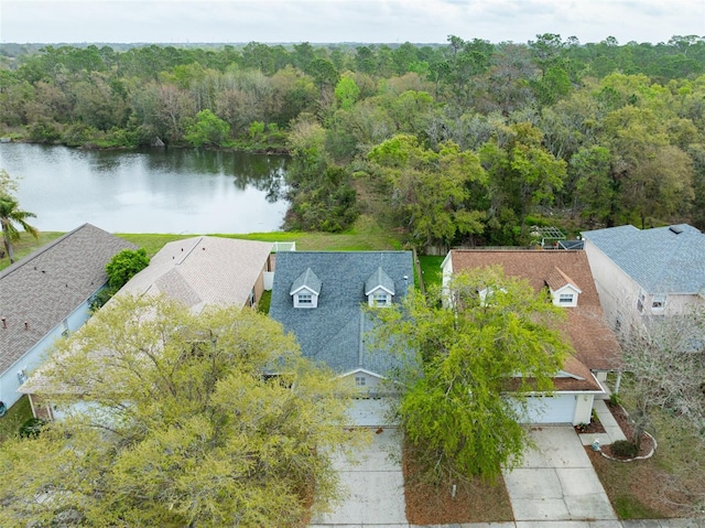 birds eye view of property with a water view and a wooded view