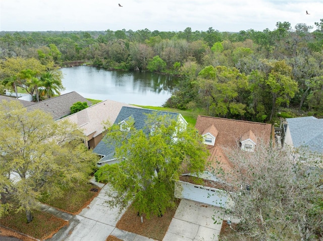 birds eye view of property featuring a forest view and a water view