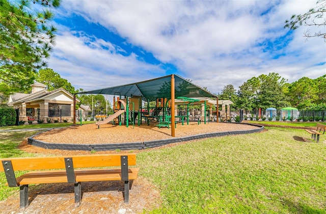 community jungle gym featuring fence and a yard