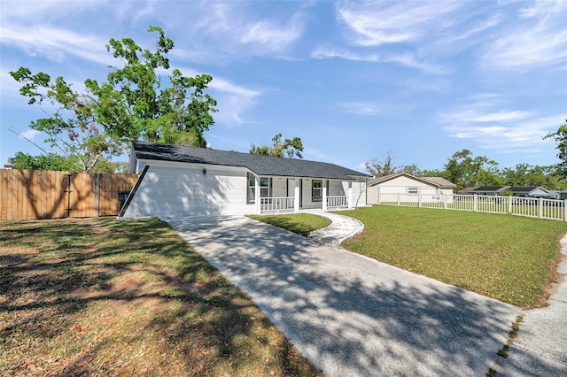 view of front of home featuring concrete driveway, a porch, a front lawn, and fence