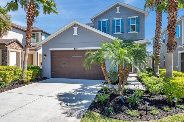 traditional-style house with an attached garage, concrete driveway, and stucco siding