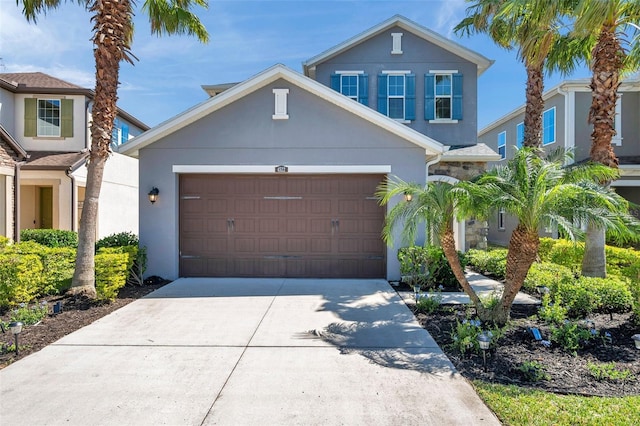 traditional home with a garage, driveway, and stucco siding