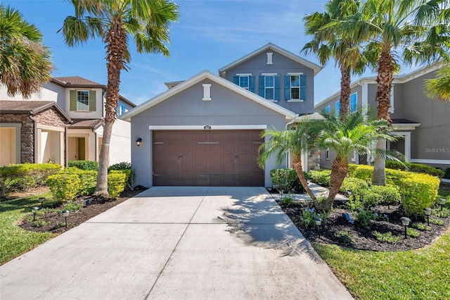 view of front of home featuring a garage, concrete driveway, and stucco siding