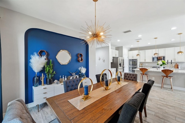 dining room with light wood finished floors, baseboards, visible vents, a notable chandelier, and recessed lighting