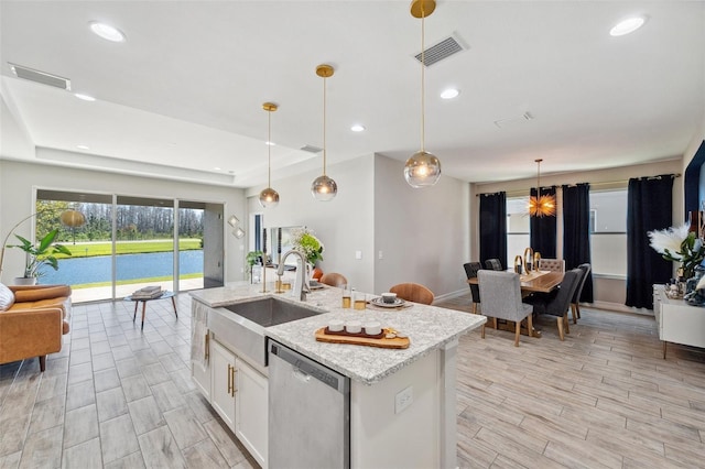 kitchen with a sink, visible vents, white cabinets, and dishwasher