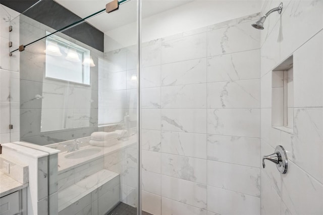 full bath featuring tiled shower and vanity