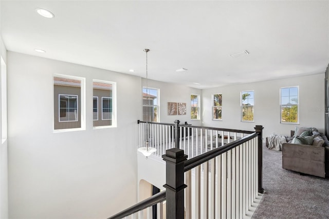 hall with recessed lighting, plenty of natural light, carpet, and an upstairs landing