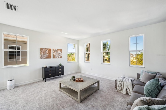 carpeted living area featuring baseboards and visible vents