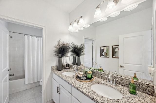 bathroom featuring toilet, tile patterned flooring, double vanity, and a sink