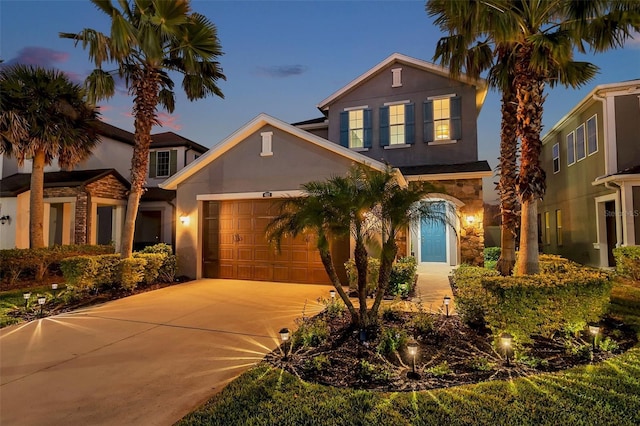 view of front of home featuring a garage, concrete driveway, and stucco siding