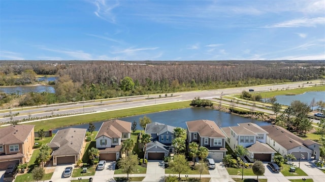 birds eye view of property featuring a forest view, a water view, and a residential view