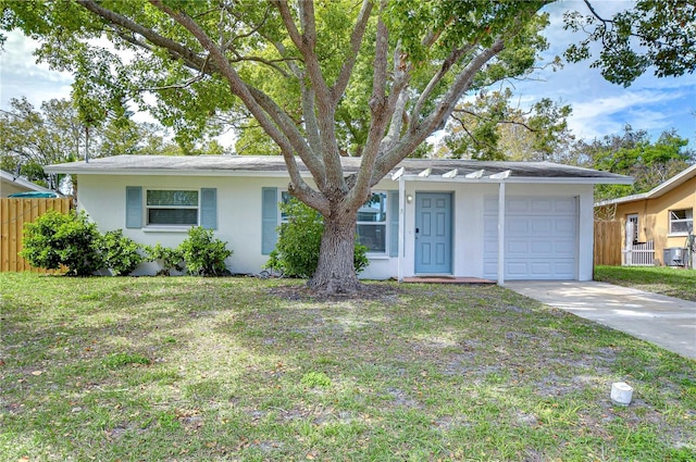 ranch-style house with a garage, fence, driveway, stucco siding, and a front yard