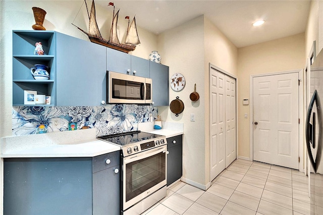 kitchen with open shelves, stainless steel appliances, gray cabinets, and light countertops