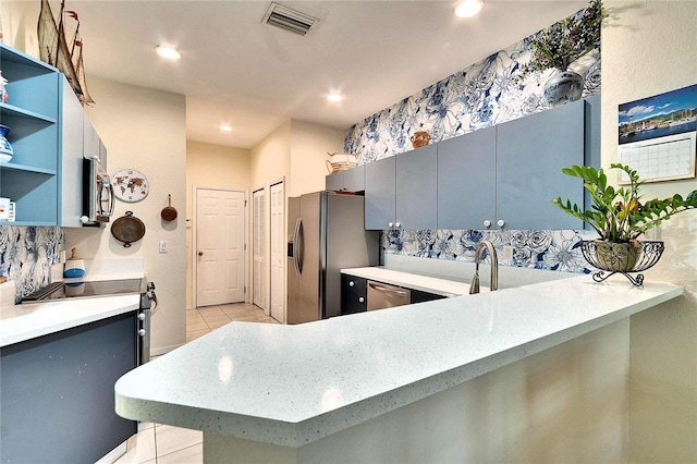 kitchen featuring visible vents, gray cabinetry, open shelves, tasteful backsplash, and appliances with stainless steel finishes